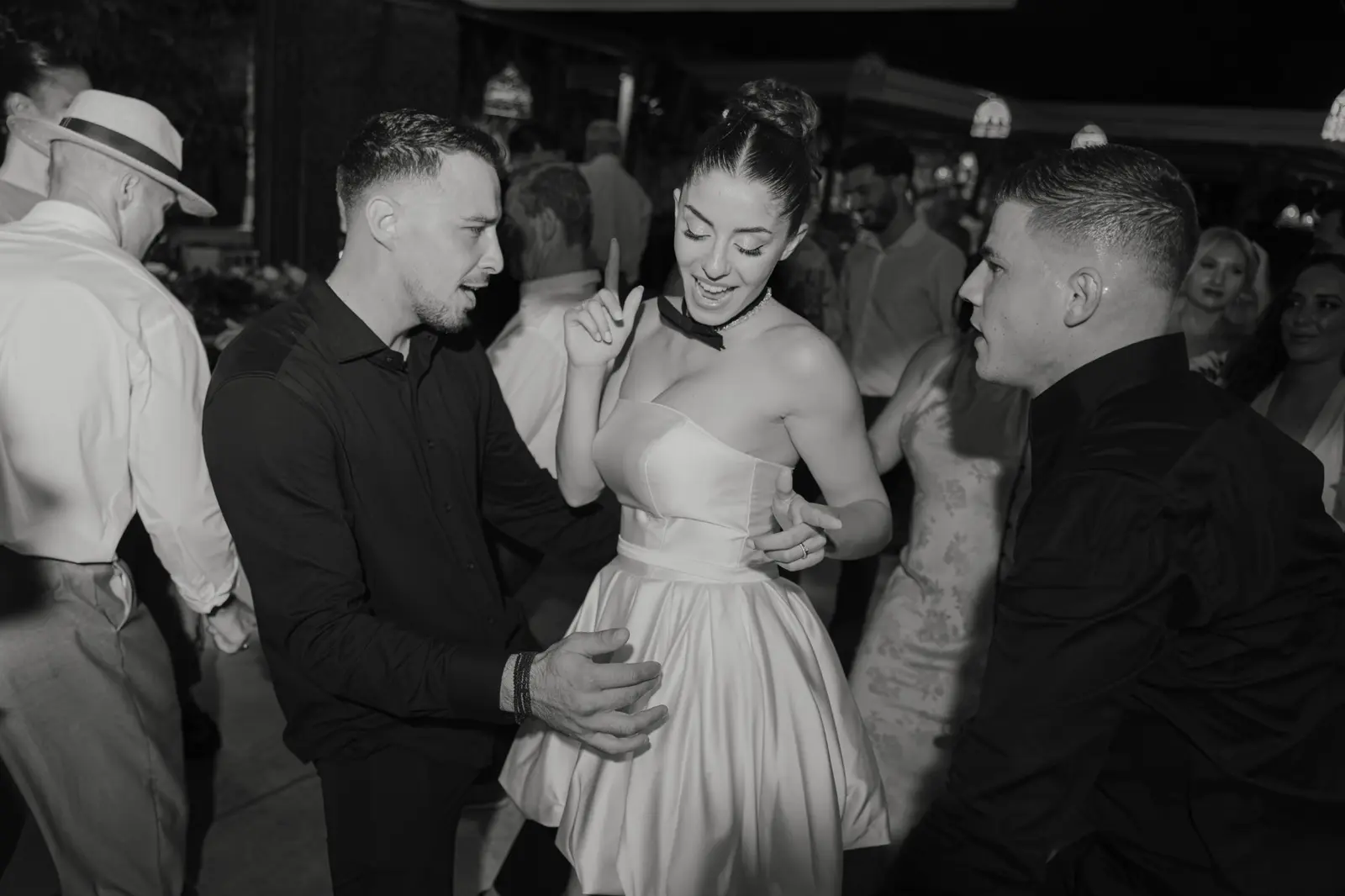 Bride dancing with wedding guests in black and white