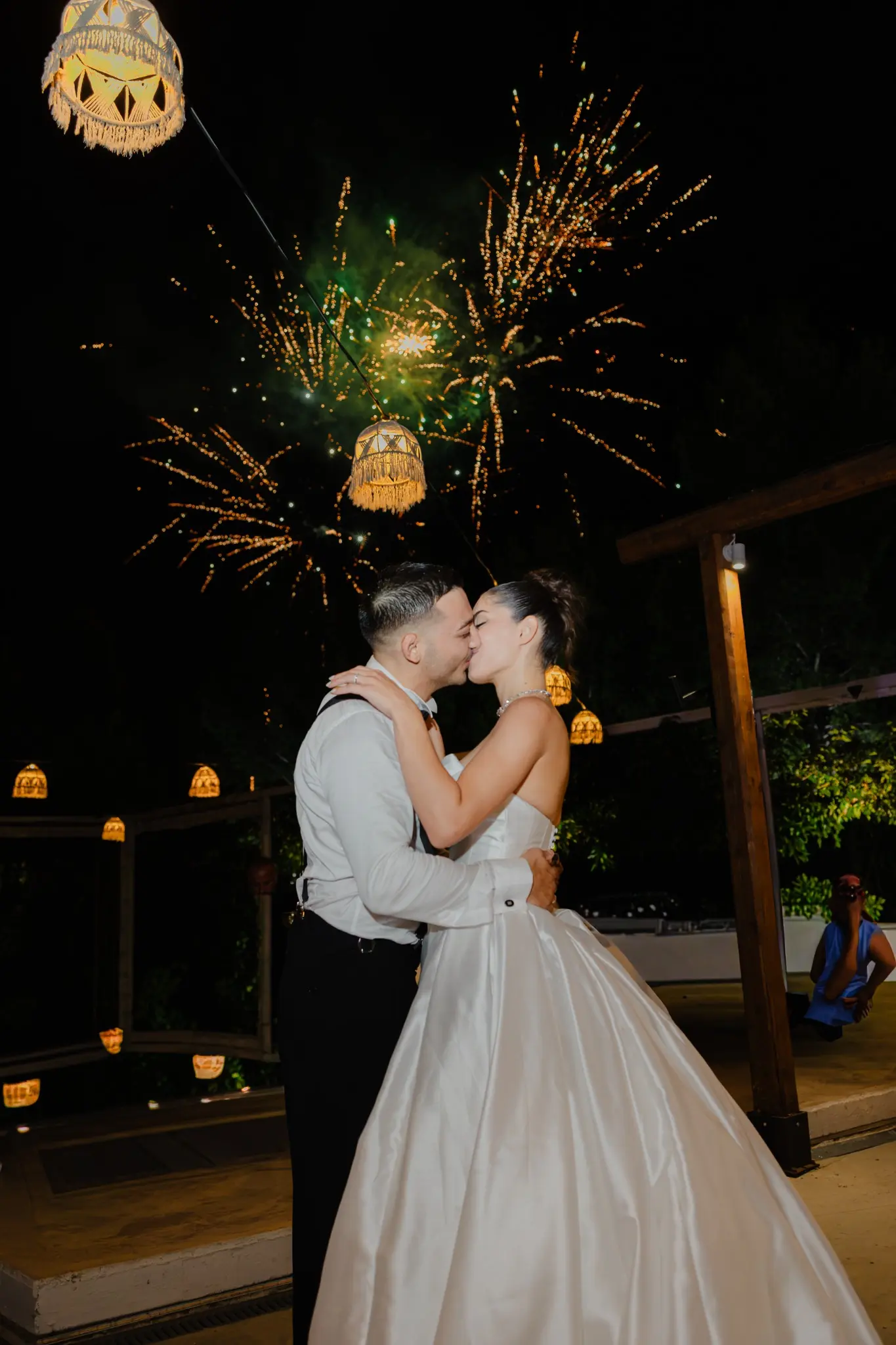 Couple celebrating under fireworks at night