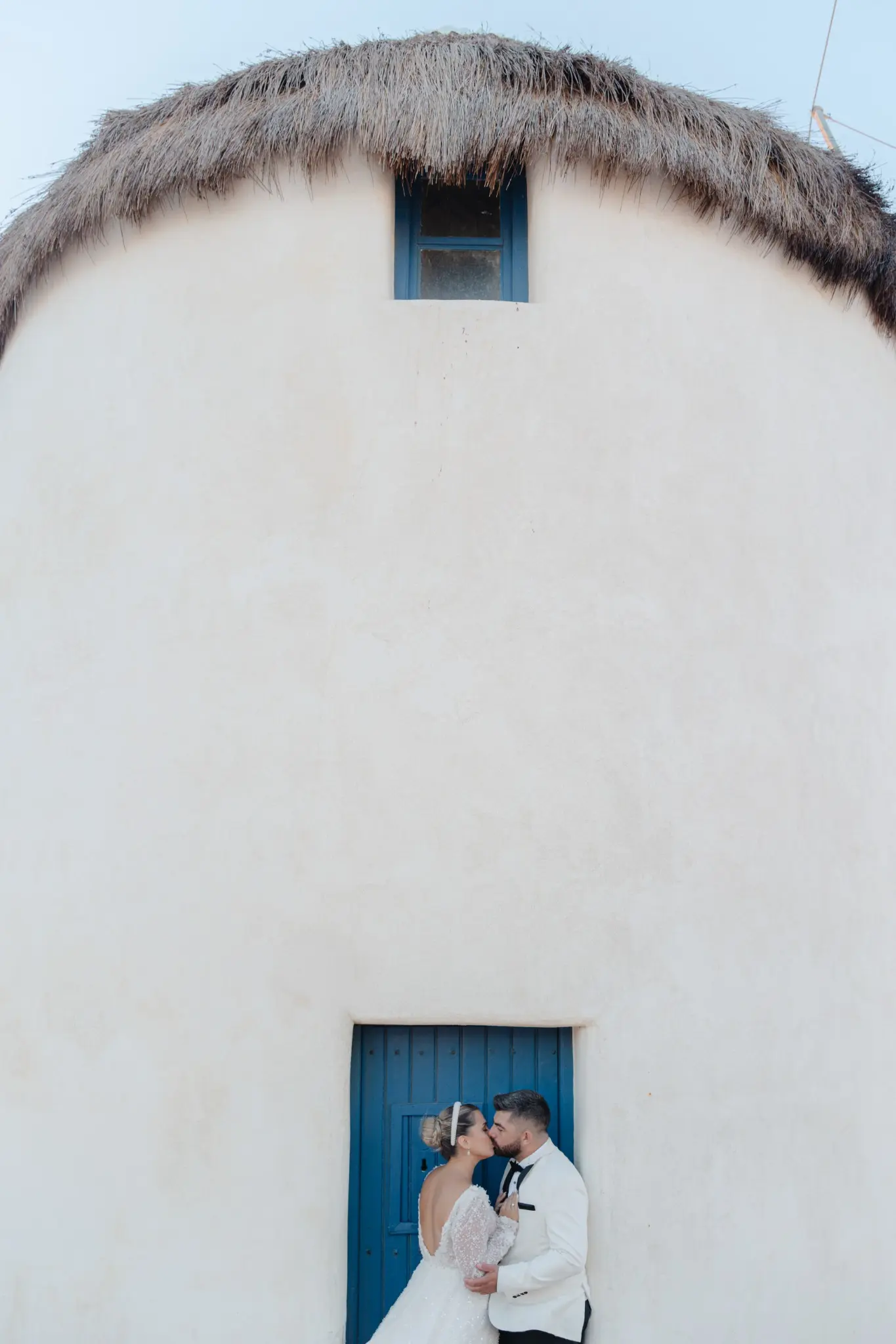 Couple at a sunlit Greek island chapel doorway
