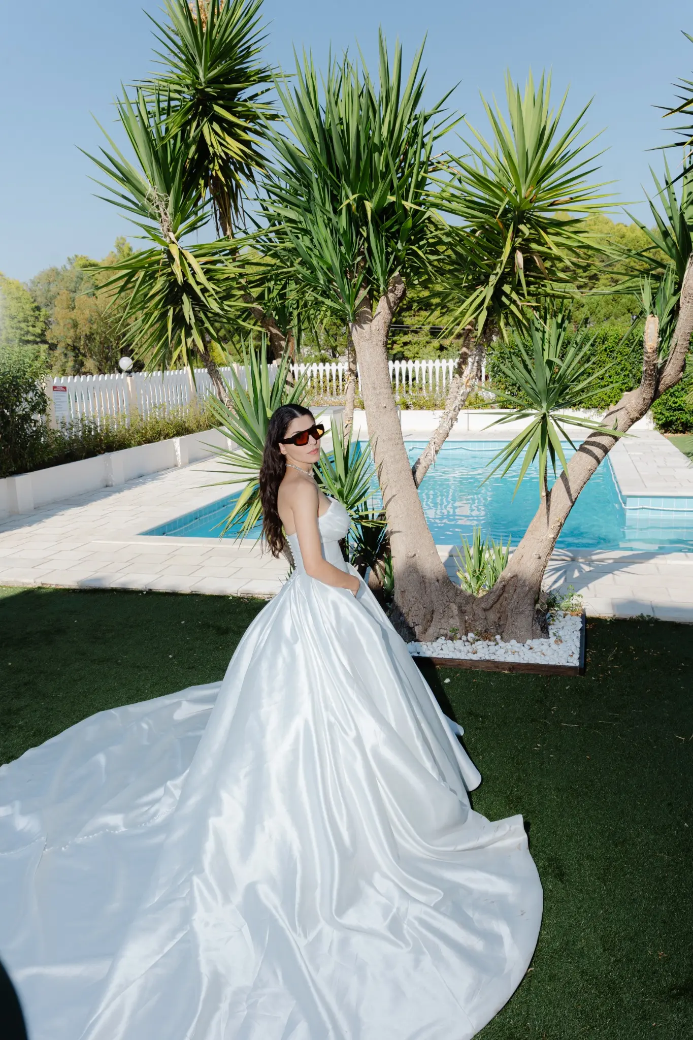 Bride lifting her bouquet near lush palms