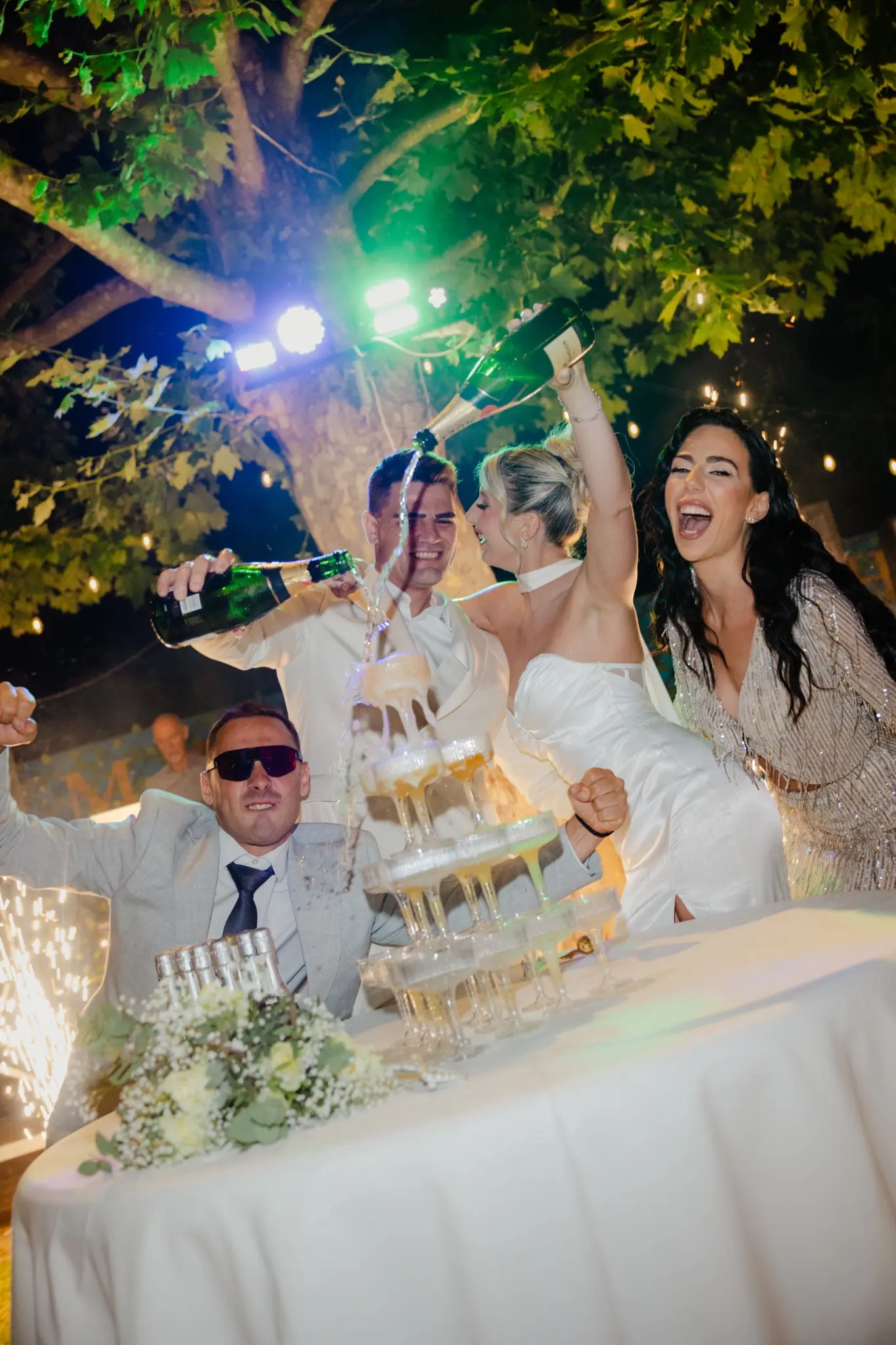Wedding guests celebrating under colorful lights