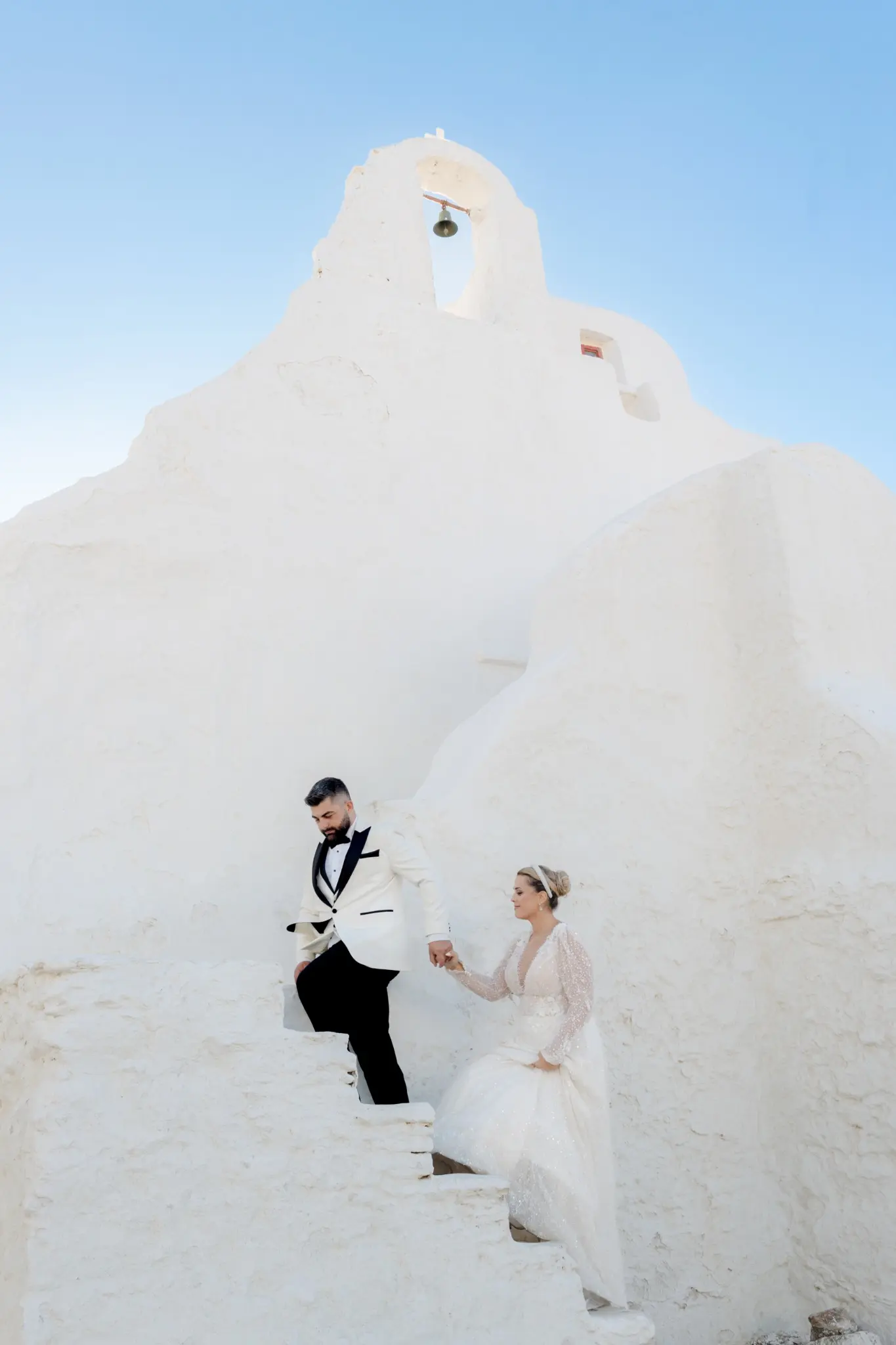 Couple against sculptural white Greek island architecture