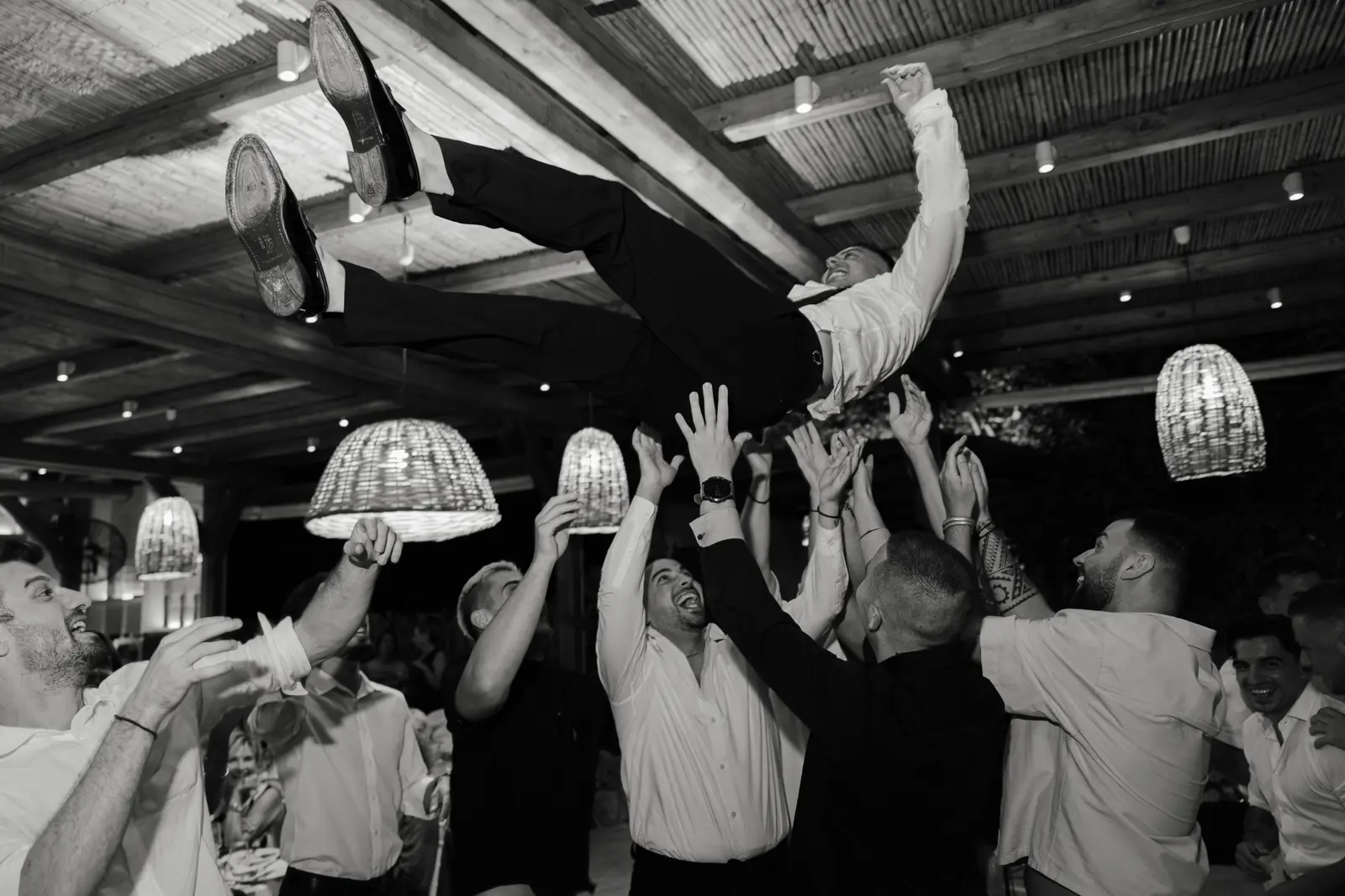 Wedding guests dancing beneath hanging lights